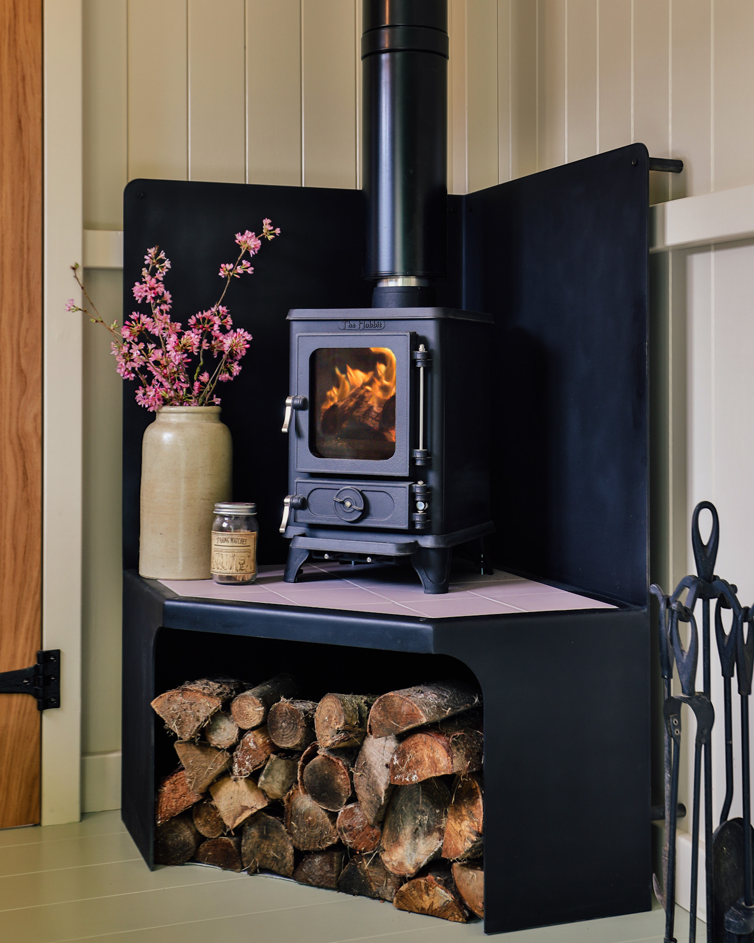 An image of a wood burning stove within a cabin with the fire lit.